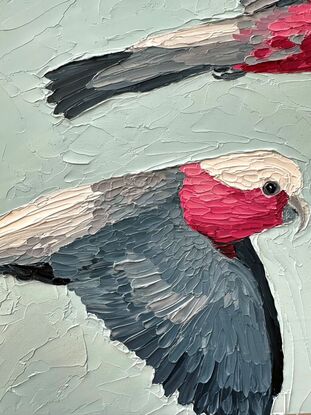 A textured oil painting of two pink galahs flying across the blue sky.