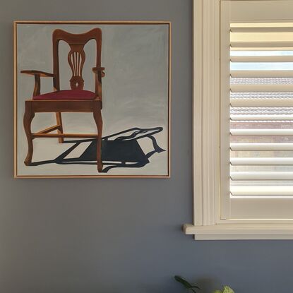 A timber chair with strong shadow.   Framed in Tasmanian Oak. 