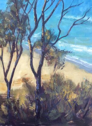 Looking through trees towards the azure water of an Australian beach, with gently waves rolling to shore.