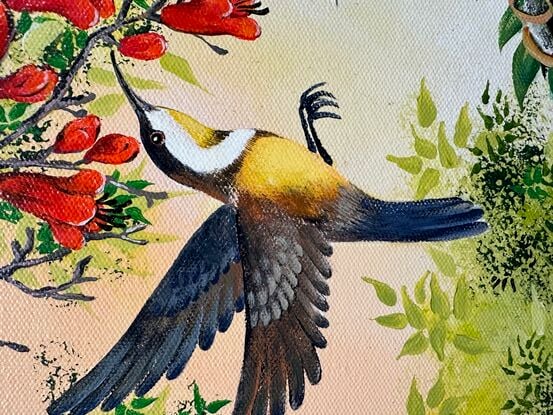 Two Honey Eaters are feeding in a red flowering tree. There is lots of green foliage against a soft golden sky