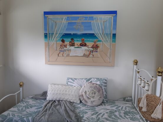 Four women sitting at a table by the beach