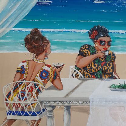 Four women sitting at a table by the beach