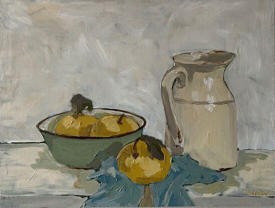 A still life scene with light green enamel bowl with light yellow nashi pears in it. To the right is an old ceramic cream coloured milk jug and they both sit on a light blue tea towel crumpled underneath. The background is white