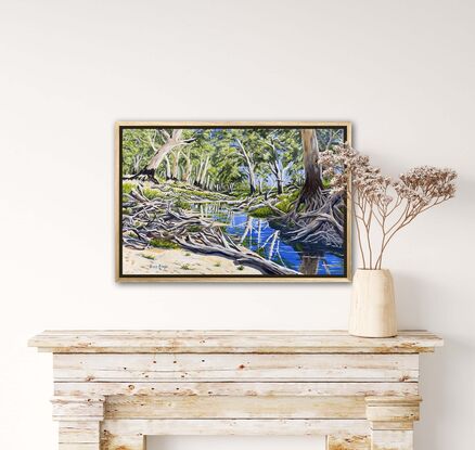 Reflections of  gums in the water of a shallow sandy creek, with lots of driftwood on the banks.