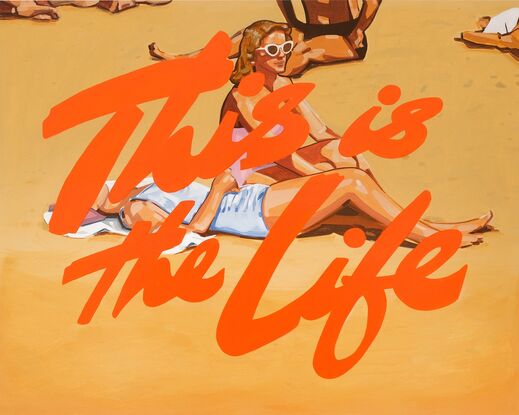 Two women are next to each other at the beach, one is sitting up wearing pink bathers and white sunglasses. The other is lying down on a white towel with blue bathers on and her legs extended. The women are surrounded by other sun bakers on a sunny day. There is a bright orange cursive text overlay reading This is the Life.