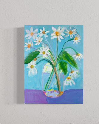 Garden daisy’s in glass vase with blue  background. Relaxing and peaceful scene 