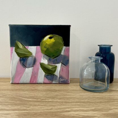 Green apple still life on a pink and white striped tea towel 