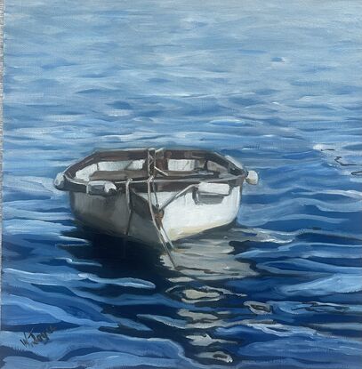 A white rowing boat with wooden trim floats front on on rippling blue water, creating an interesting reflection on the water’s surface. Framed in limed white wood and ready to hang.