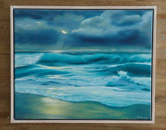 blue ocean waves under stormy sky with sun peeking through clouds