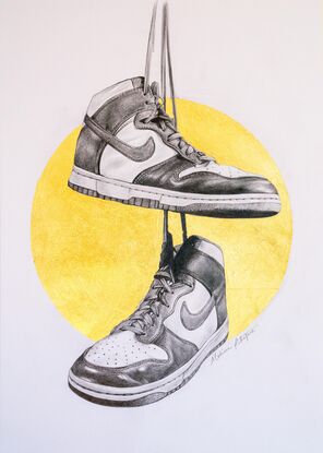 A graphite balck and white drawing of two Nike Dunk high top shoes hanging from their shoe laces from height reminiscent of telegraph wires. Behind the shoes is a gold metallic halo. 