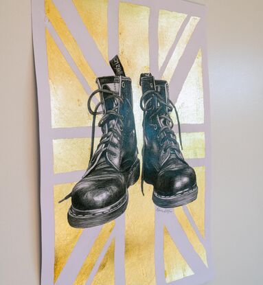 A graphite black and white drawing of two Doctor Martens boots. Behind the shoes is a gold metallic Union Jack. 