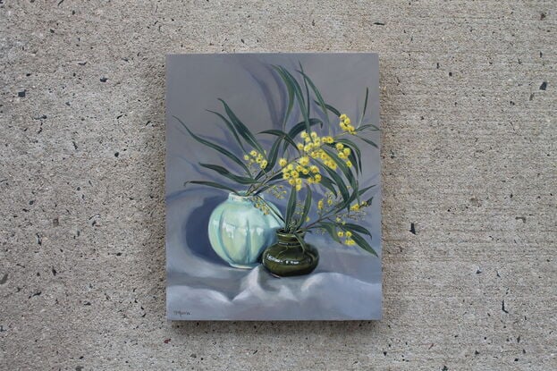 Yellow wattle in vintage green vases