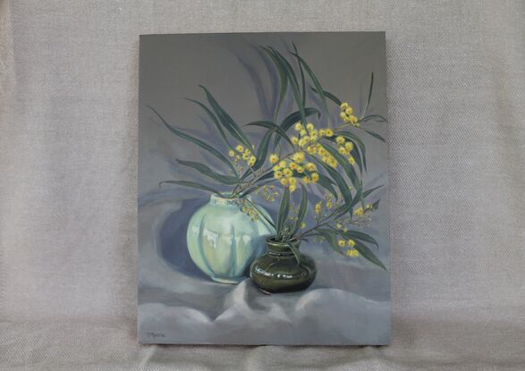 Yellow wattle in vintage green vases