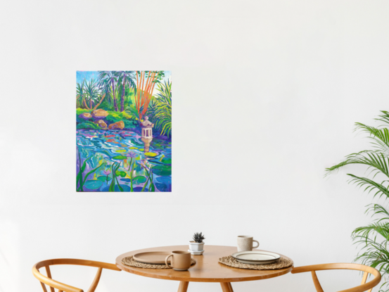 Colourful view of a lagoon with waterlilies and water feature with palms and bamboo in the background.