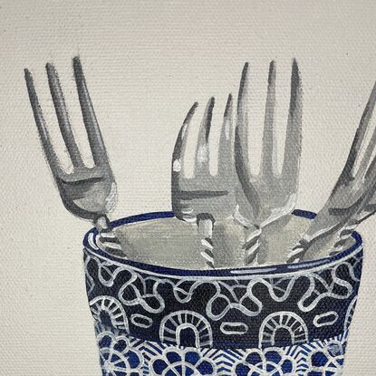 blue and white cup with silver forks