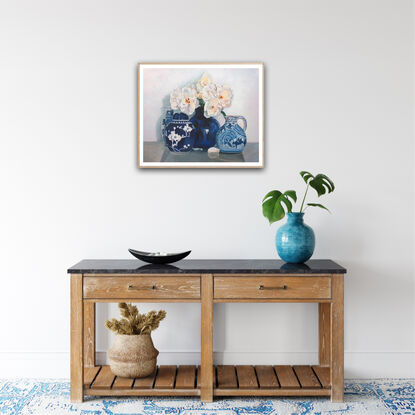 White iceberg roses in a blue and white ceramic vase, with other vases. 