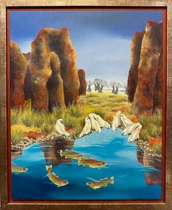 Barramundi swim in the waterhole while a flock of birds have gathered for a drink. A scene in the outback of Australia with overpowering red rocks in the foreground and boab trees at a distance.