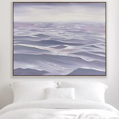 Gentle close up ripples and waves on an ocean surface in light purple and grey