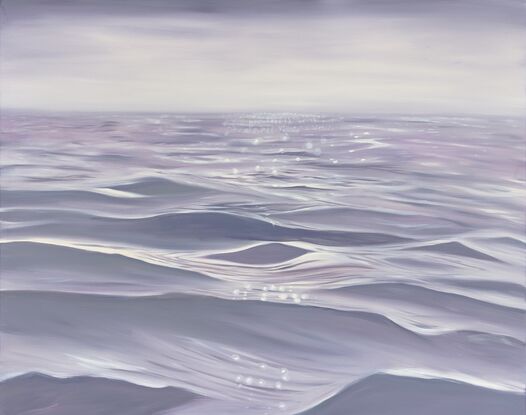 Gentle close up ripples and waves on an ocean surface in light purple and grey