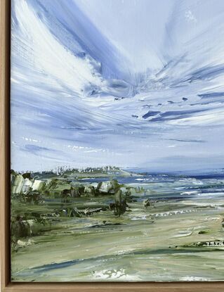 Light clouds in blue sky over ocean beach sand trees coastline