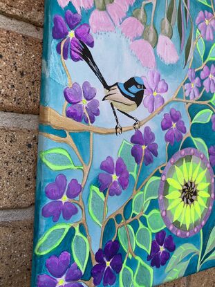 A little blue wren amongst purple flowers.