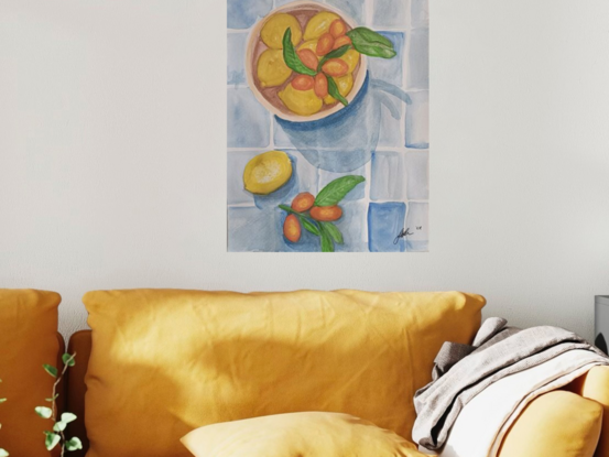 This artwork is a still life painting of lemons and cumquats in a bowl. The artist has used a variety of watercolor techniques to create a realistic and textured depiction of the fruits. The lemons are bright yellow and the cumquats are a vibrant orange. The background is a simple blue and white tile pattern which provides a contrast to the colourful fruits. The overall effect is one of freshness and abundance.