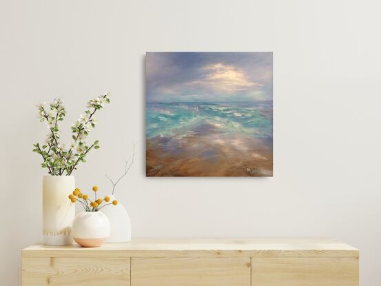 Ocean waves criss-crossing with blue sky and white clouds and sandy beach.