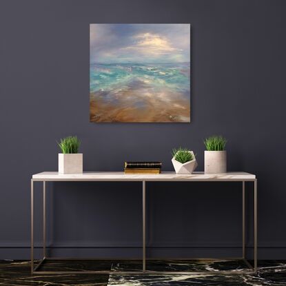 Ocean waves criss-crossing with blue sky and white clouds and sandy beach.