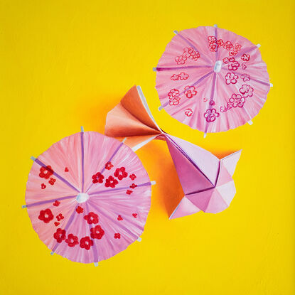 Two origami koi on a golden yellow background.