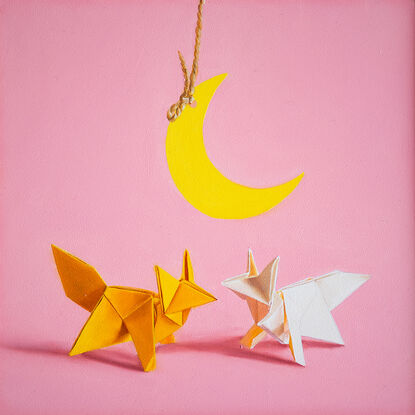 two origami foxes meeting under a hanging paper moon. the mood is fun and playful