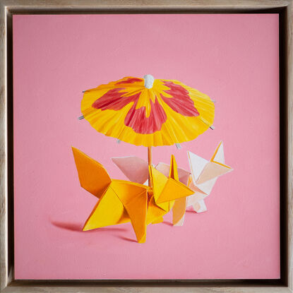 two origami foxes together under a cocktail parasol. the mood is fun and playful