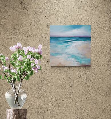 Gentle waves roll onto a sandy beach under a sky filled with cloud cover, creating a serene and calming scene. The hues of blue and green blend harmoniously, portraying the natural beauty of the coastal landscape. There are multiple layers of acrylic paint that gives the piece nuance, depth, and interest. The side edges are painted black and it is wired ready to hang. A clear UV protective finish coat finish the piece.