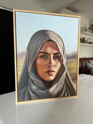 This oil painting captures a realistic and powerful portrait of a woman in a headscarf, with striking details and a serene yet intense expression.