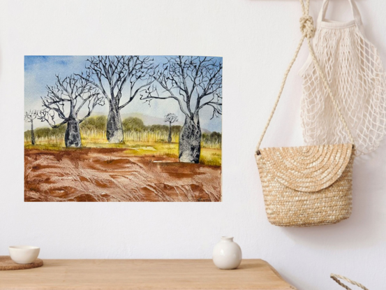 Boab Trees on red earth with blue sky and distant mountain and scrub part of an Australian landscape 