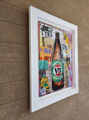 Paper collage artwork depicting a VB longneck beer bottle on canvas board, framed.