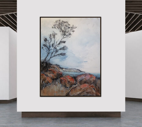 A seascape of the the Bay Of Fires in Tasmania with a tree and clouds