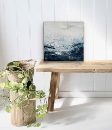 An ocean inspired textured small original painting in a moody predominantly deep blue and off white palette with a hint of silver