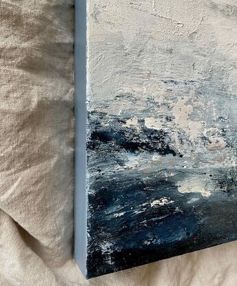 An ocean inspired textured small original painting in a moody predominantly deep blue and off white palette with a hint of silver