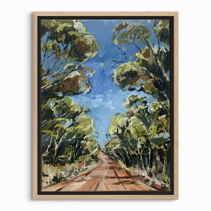 A red track is bordered by swaying gumtrees that make an archway.  There is a blue sky. 