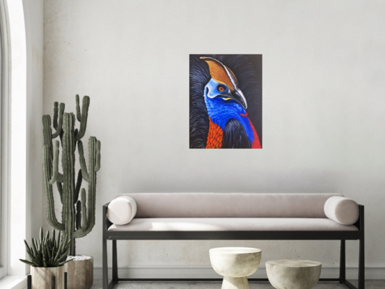 A beautiful majestic bird native to Australia, this cassowary is brightly coloured on a black background. It has piercing eyes that follow you around the room. The main colours are the primary colours of blue, red and yellow.