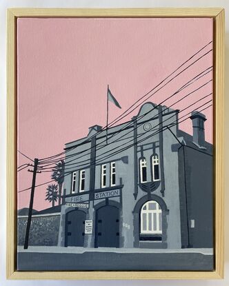 Old fire station building in grey tones with a pink sky