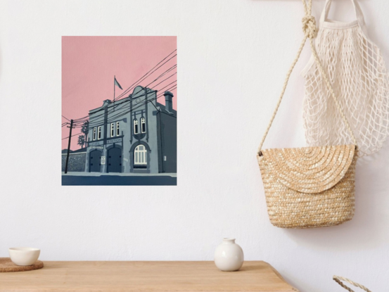 Old fire station building in grey tones with a pink sky