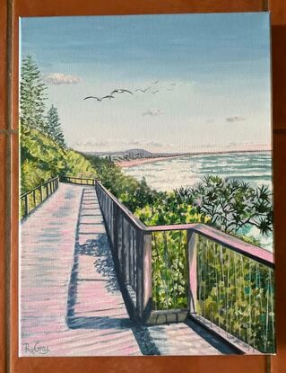 Beach boardwalk along the coast, framed by pandanus and coastal shrubs, seagulls overhead and views in distance,