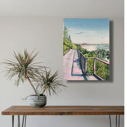 Beach boardwalk along the coast, framed by pandanus and coastal shrubs, seagulls overhead and views in distance,