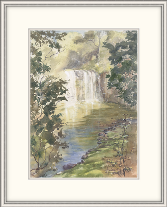 Waterfall in sunlight and shade with surrounding trees and rocks