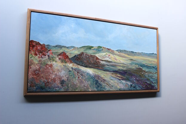 Painting of a multi-coloured desert with a wide view of a stunning landscape