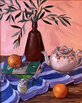 A table top with a brown vase full of olive leaves, a white decorative vintage teapot, some old mystery novels, a mustard jar and oranges on a purple striped table cloth. 