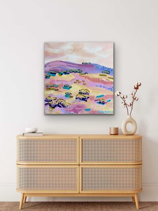 A view of distant cattle grazing in the pink, mango, lemon, and mauve fields under a warm summer afternoon sky.