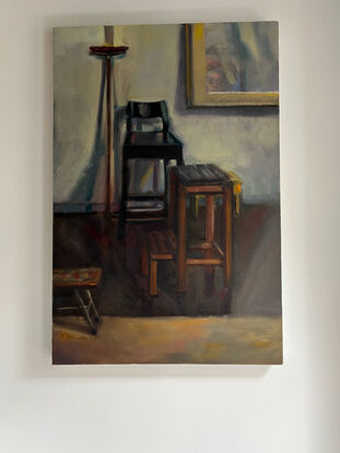 A painting of a broom chair, and several stools with a painting in the background, with a touch of surrealism.