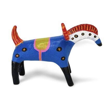 The Horned Wanderer sculpture features a bold blue body with vibrant red, curved horns and black legs, accented by colorful patterns and dotted details. 